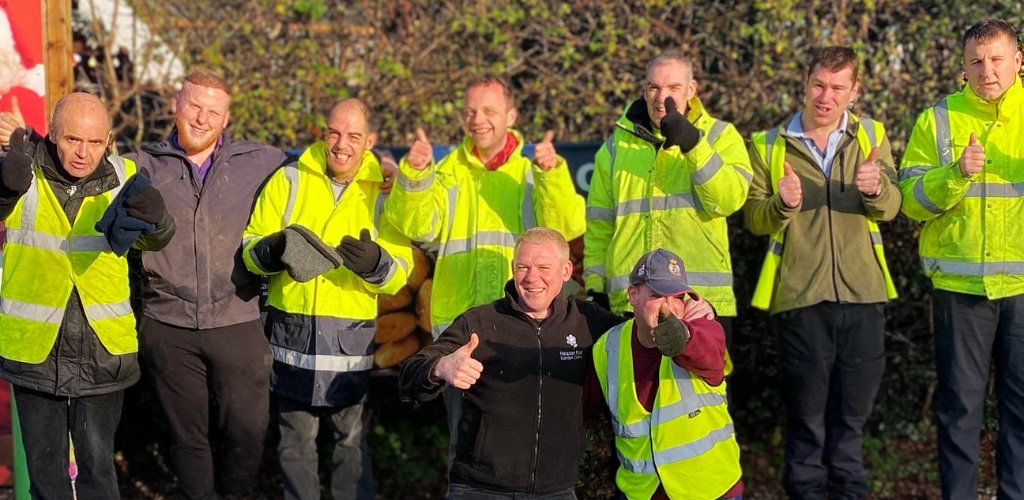 A group of students wearing hi-vis jackets standing in a group photo, ready for the Mayor of Bolton's arrival.